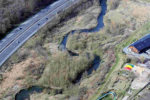Luftbild auf einen gewundenen Flusslauf, Wiese,Industriegebäude,  Autobahn