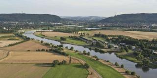 Luftbild, breiter Fluss, ebene Landschaft mit Äckern und Wiesen, Gebirgszug am Horizont